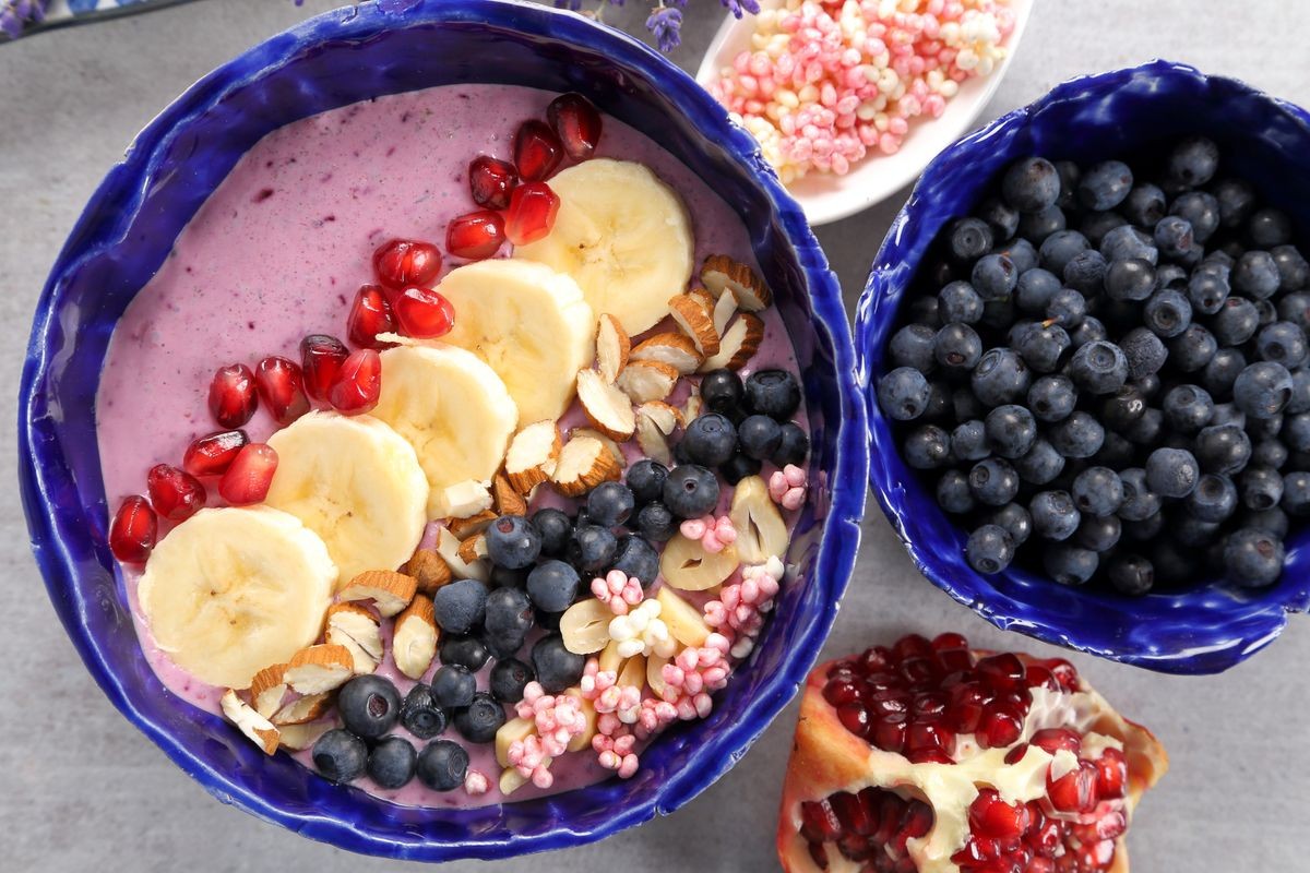 Healthy blueberry smoothie bowl with bannan, grenade, almonds, millet gruel.