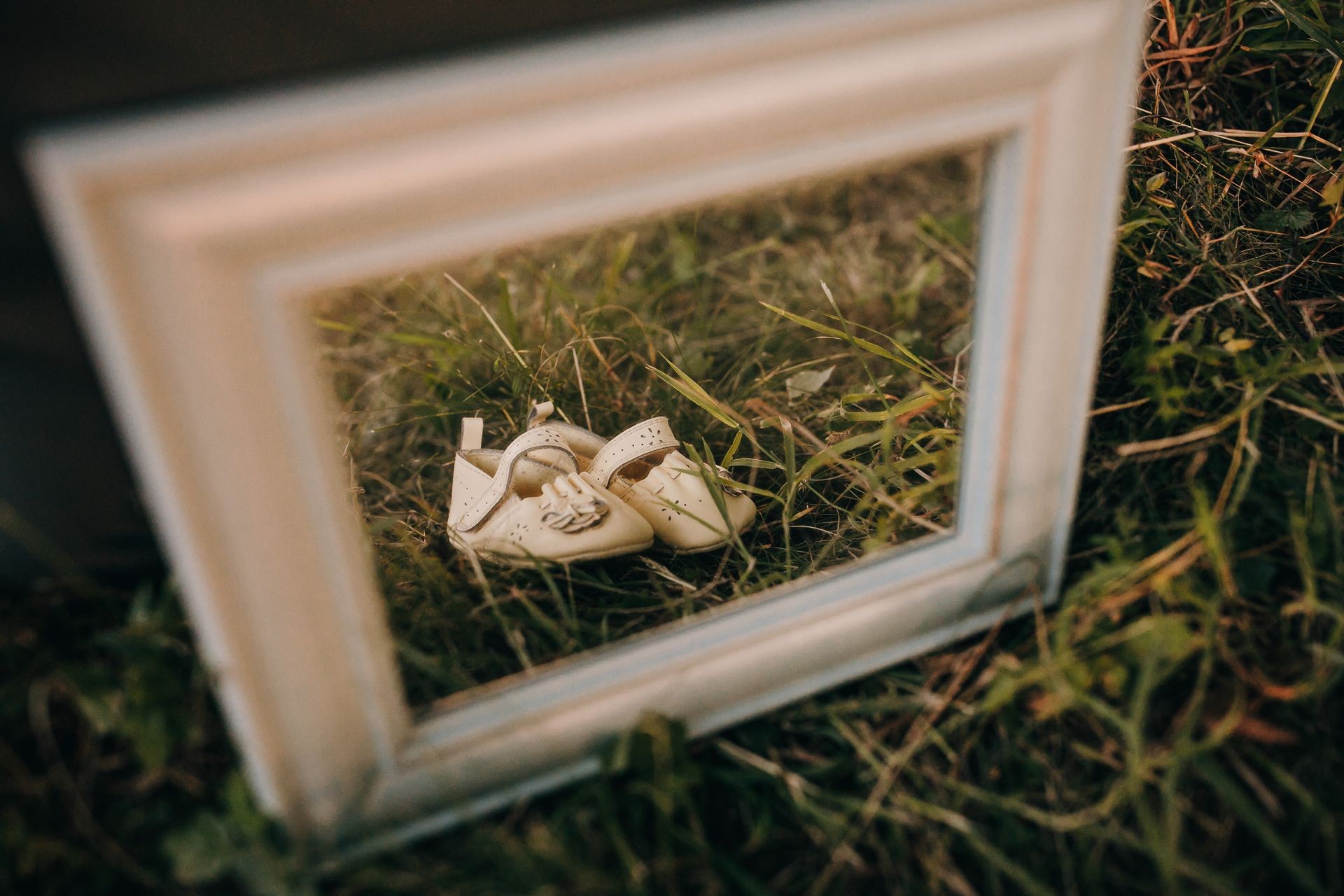 Baby shoes in frame for photo in sunset